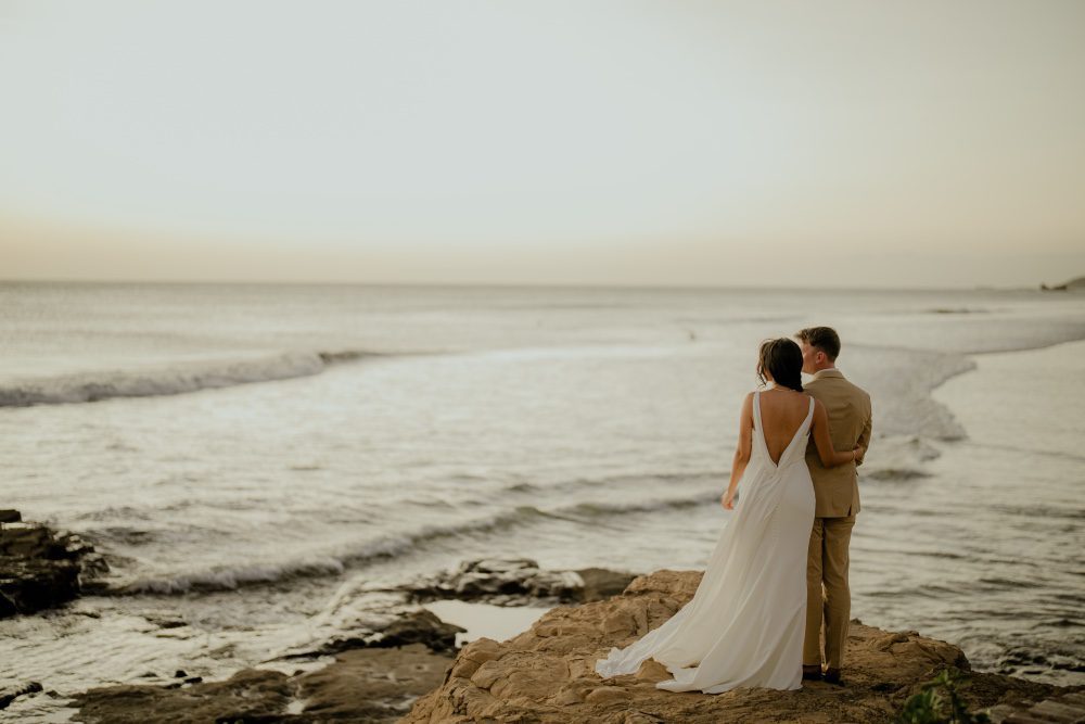 A couple standing with a beach background celebrating at Rancho Santana destination wedding locations.