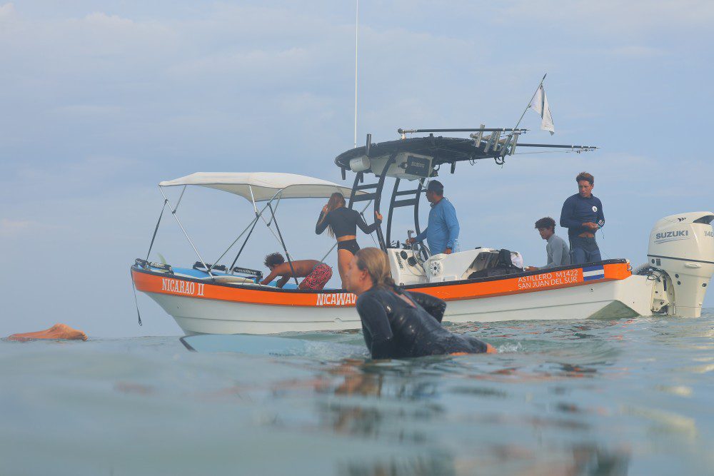 picture of a surfer on the emerald coast of Nicaragua surfing with from a boat with Rancho Santana surf teachers